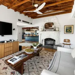 Living room with wooden ceiling, fireplace, and TV at Hillside Hideaway in Topanga Canyon - by Open Air Homes