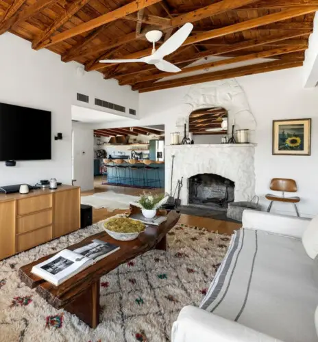 Living room with wooden ceiling, fireplace, and TV at Hillside Hideaway in Topanga Canyon - by Open Air Homes