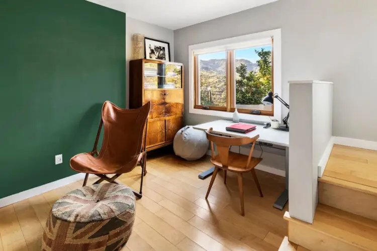 Room with green accent wall, wooden desk, and chair near window at Hillside Hideaway in Topanga Canyon - by Open Air Homes