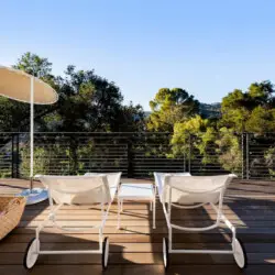 Deck area with lounge chairs, table, and umbrella at Hillside Hideaway in Topanga Canyon.