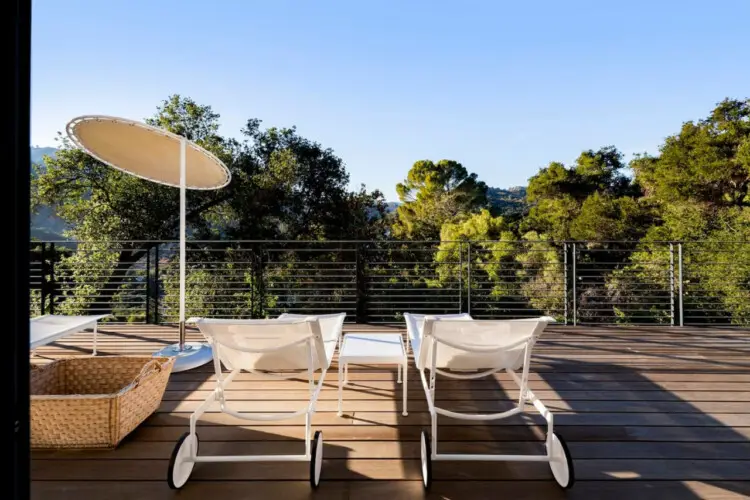 Deck area with lounge chairs, table, and umbrella at Hillside Hideaway in Topanga Canyon.