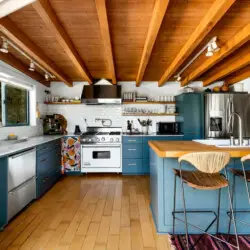 Kitchen with wooden ceiling, blue cabinets, and island at Hillside Hideaway in Topanga Canyon - by Open Air Homes