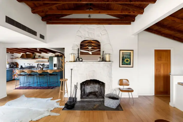 Living room with white fireplace and wooden ceiling at Hillside Hideaway in Topanga Canyon - by Open Air Homes