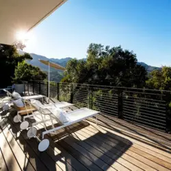 Outdoor deck with loungers at Hillside Hideaway w/ Spa in Topanga Canyon with scenic hill views by Open Air Homes.