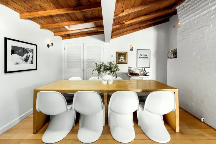 Dining area with wooden ceiling, table, and white chairs at Hillside Hideaway in Topanga Canyon - by Open Air Homes