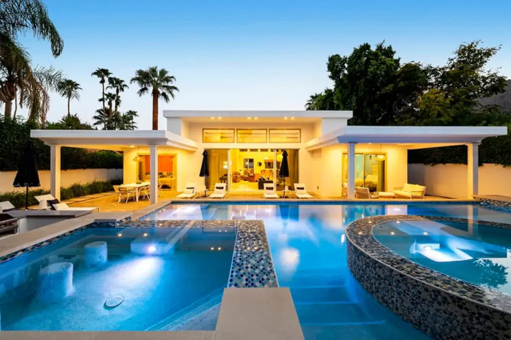 Ocotillo by Open Air Homes 7 Luxurious pool area with modern house and palm trees in a luxury vacation rental – Open Air Homes.