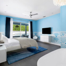 Bedroom with a bed, freestanding bathtub, and gold-framed mirror at Ocotillo, Palm Springs