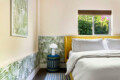 Bedroom with a bed, bedside table, and decorative wall at Ocotillo, Palm Springs