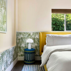 Bedroom with a bed, bedside table, and decorative wall at Ocotillo, Palm Springs