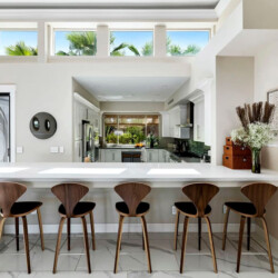 Kitchen with white cabinets, countertop, and bar stools at Ocotillo, Palm Springs