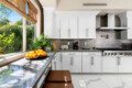 Modern kitchen with white cabinets, countertop, and garden view at Ocotillo, Palm Springs