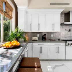 Modern kitchen with white cabinets, countertop, and garden view at Ocotillo, Palm Springs