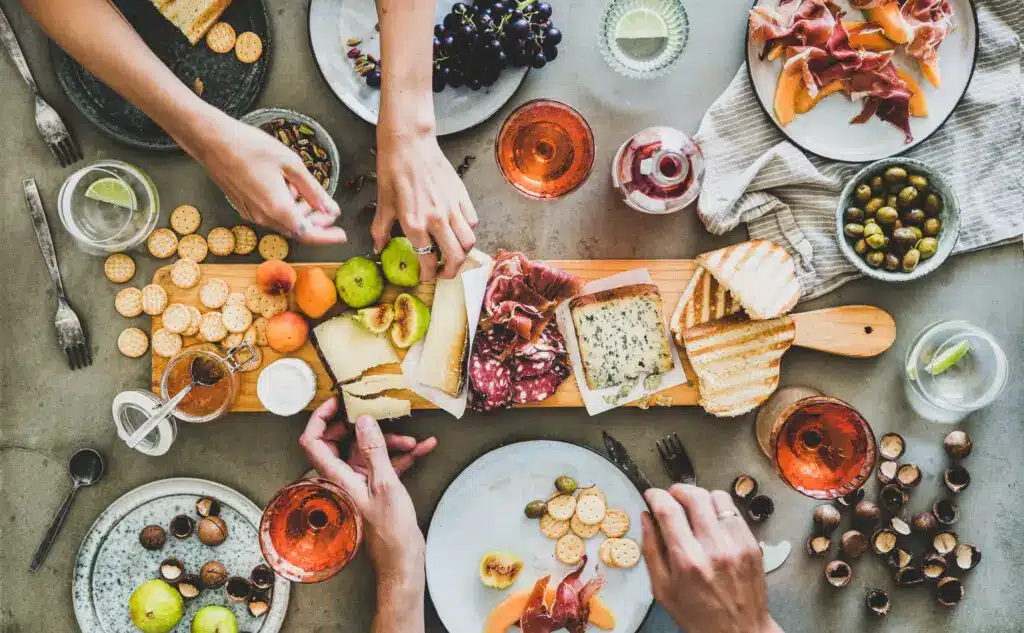 Summer picnic with wine and snacks, including a charcuterie board and rose wine