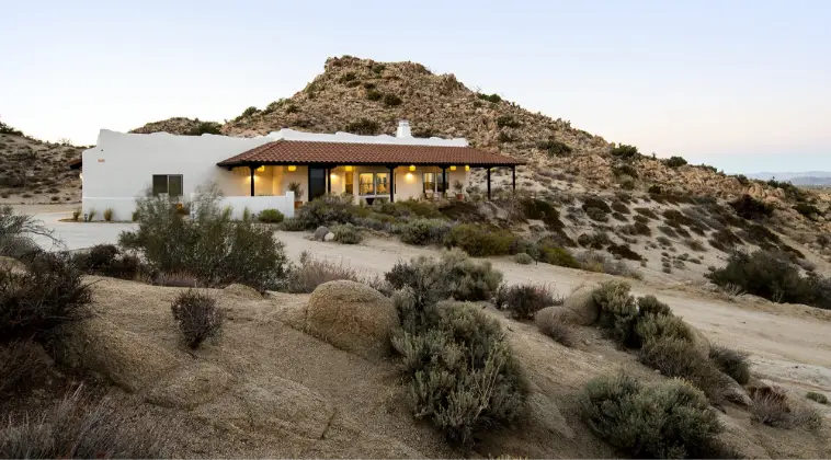 House in desert landscape with mountains