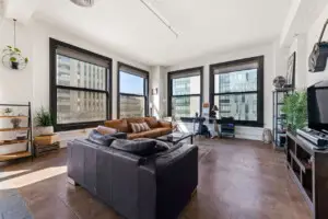 Modern living room with leather sofa and city skyline view by Open Air Homes.