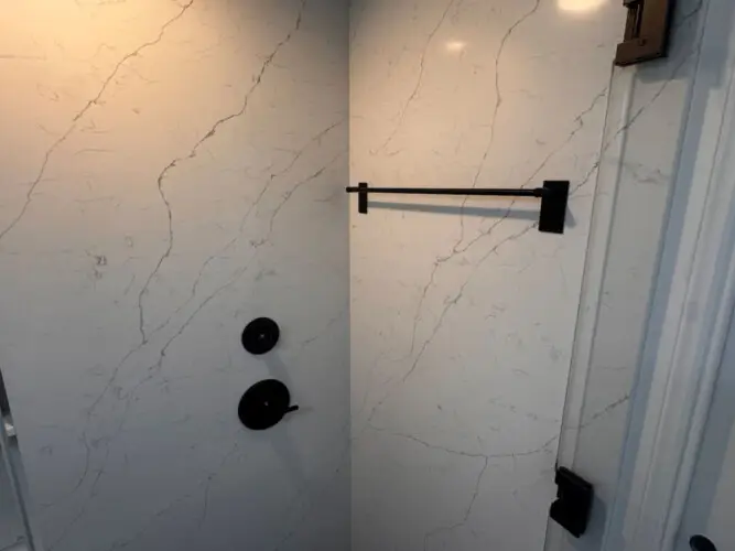 Shower area with towel rack and marble tiles at Malibu Breeze.