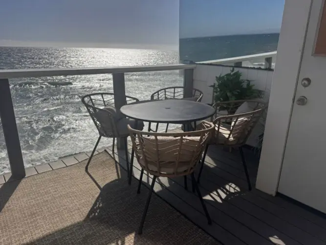 Patio area with table and chairs overlooking the ocean at Malibu Breeze.