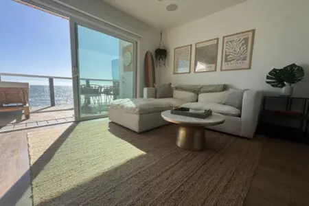 Living room area with sofa, coffee table, and ocean view at Malibu Breeze