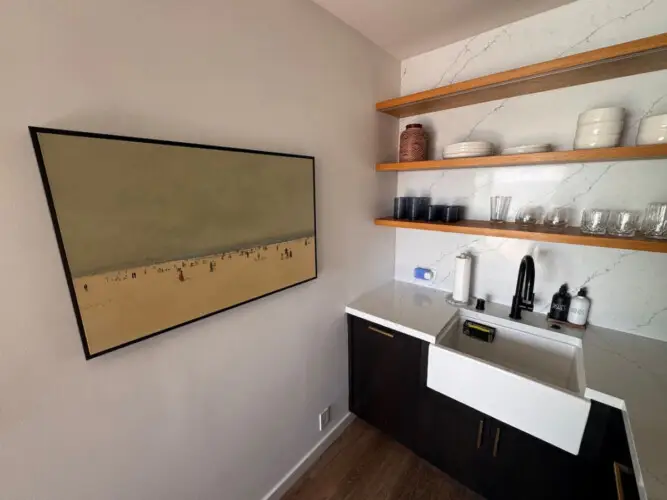 Kitchen area with sink, shelves, and wall art at Malibu Breeze.