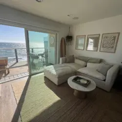 Living room with sofa, coffee table, and ocean view at Malibu Breeze.