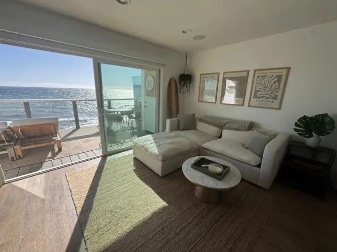 Living room with sofa, coffee table, and ocean view at Malibu Breeze.