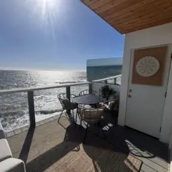 Patio area with table and chairs overlooking the ocean at Malibu Breeze.