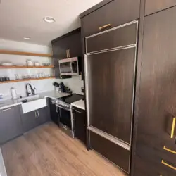 Kitchen area with sink, stove, and shelves at Malibu Breeze.