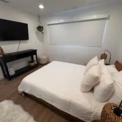 Bedroom with bed, TV, and side table at Malibu Breeze.