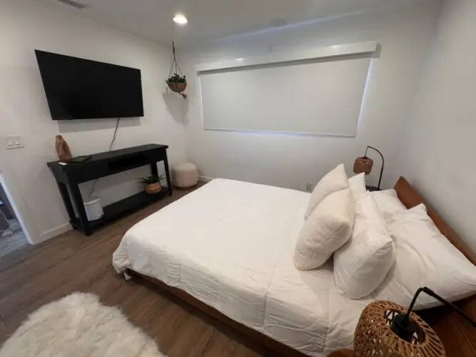 Bedroom with bed, TV, and side table at Malibu Breeze.