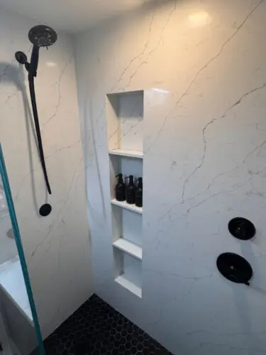 Shower area with rainfall showerhead and built-in shelves at Malibu Breeze.