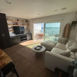 Living room with sofa, coffee table, and ocean view at Malibu Breeze.