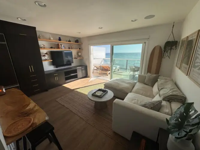 Living room with sofa, coffee table, and ocean view at Malibu Breeze.