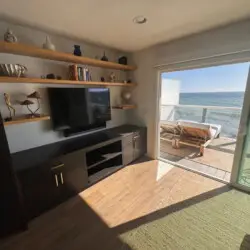 Built-in entertainment unit with TV, shelves, and cabinets at Malibu Breeze.