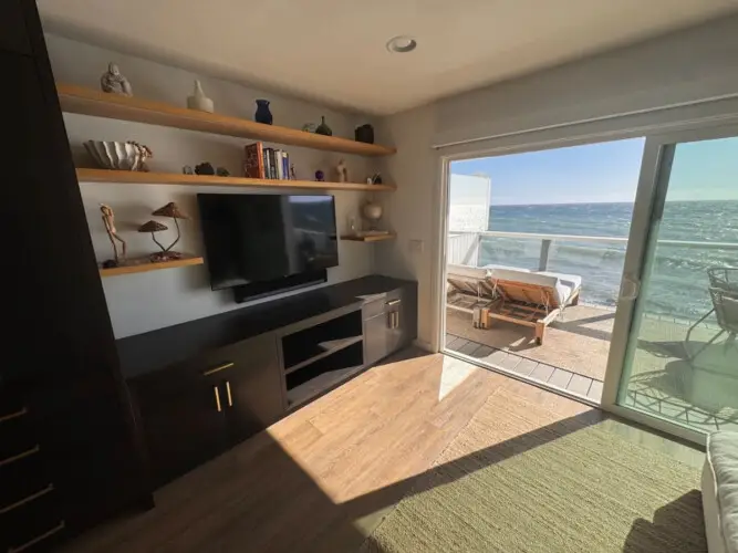 Built-in entertainment unit with TV, shelves, and cabinets at Malibu Breeze.