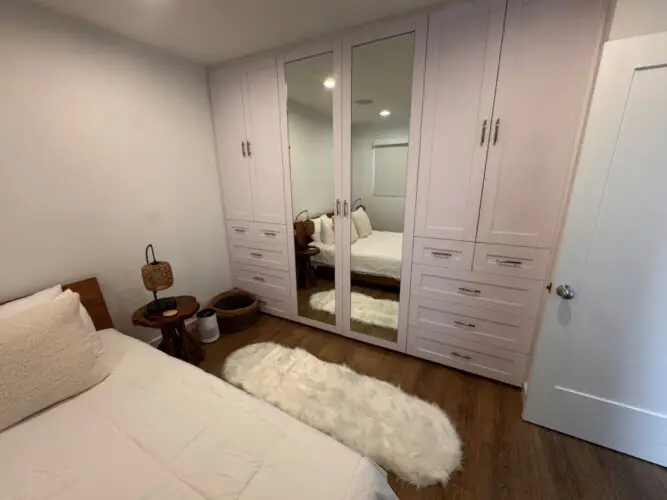 Bedroom with bed, mirrored wardrobe, and side table at Malibu Breeze.