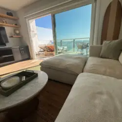 Living room with sofa, coffee table, and TV at Malibu Breeze.