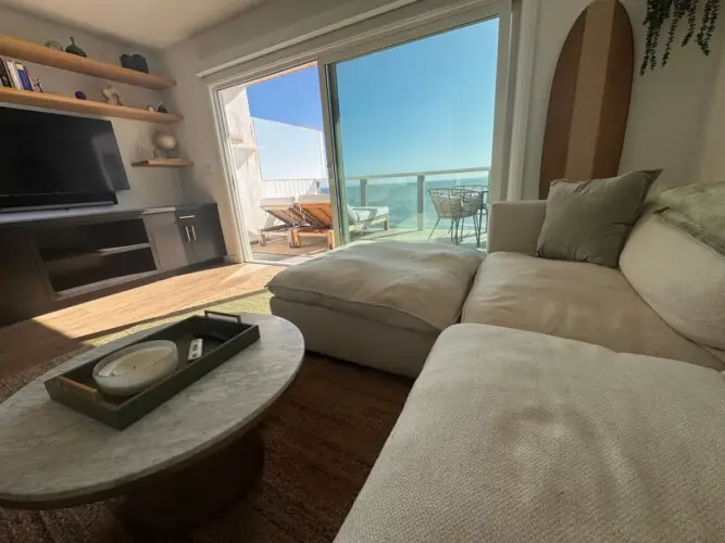 Living room with sofa, coffee table, and TV at Malibu Breeze.