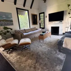 Living room with vaulted ceiling, sofa, and fireplace at Beverly Grove Tudor Family Home - by Open Air Homes.