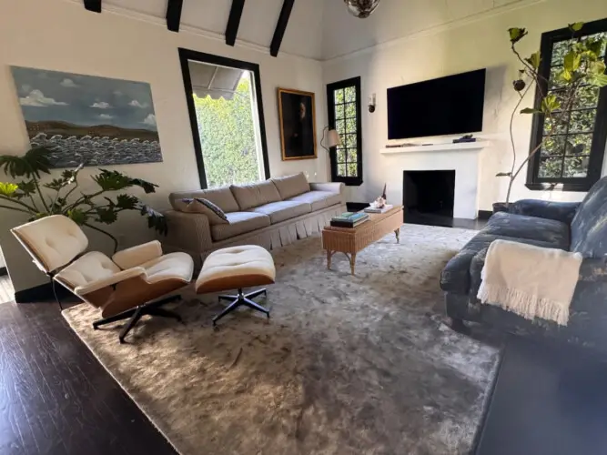 Living room with vaulted ceiling, sofa, and fireplace at Beverly Grove Tudor Family Home - by Open Air Homes.