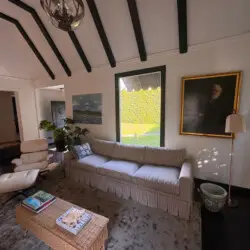 Living room with striped sofa, chair, and coffee table at Beverly Grove Tudor Family Home - by Open Air Homes.