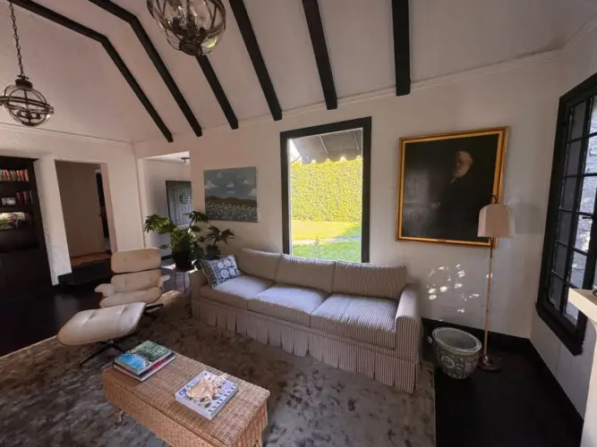 Living room with striped sofa, chair, and coffee table at Beverly Grove Tudor Family Home - by Open Air Homes.