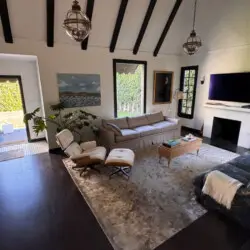 Living room with vaulted ceiling, sofa, and TV at Beverly Grove Tudor Family Home - by Open Air Homes.