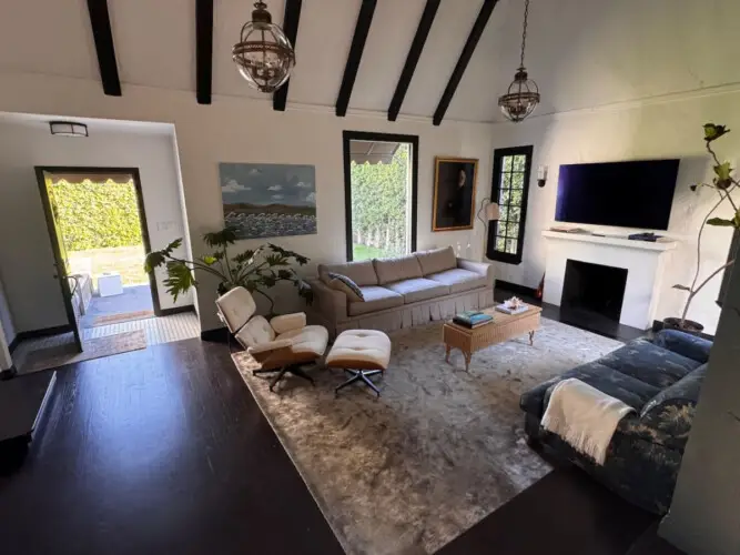 Living room with vaulted ceiling, sofa, and TV at Beverly Grove Tudor Family Home - by Open Air Homes.