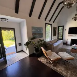 Living room with vaulted ceiling and fireplace at Beverly Grove Tudor Family Home - by Open Air Homes.