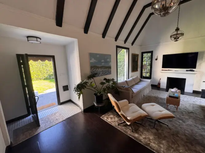 Living room with vaulted ceiling and fireplace at Beverly Grove Tudor Family Home - by Open Air Homes.