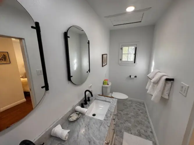 Bathroom with marble countertop at Beverly Grove Tudor Family Home - by Open Air Homes.