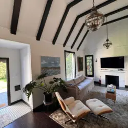 Living room with vaulted ceiling, sofa, and chair at Beverly Grove Tudor Family Home - by Open Air Homes.