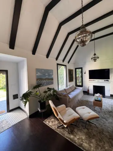 Living room with vaulted ceiling, sofa, and chair at Beverly Grove Tudor Family Home - by Open Air Homes.