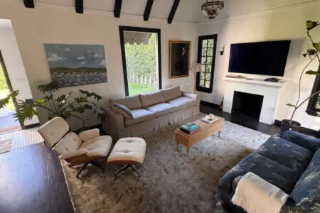 Living room with sofa, armchairs, and wall-mounted TV at Beverly Grove Tudor Family Home - by Open Air Homes.