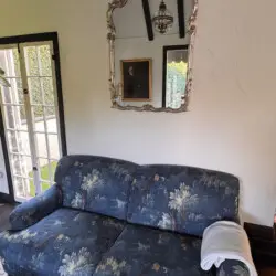 Blue floral sofa with mirror and framed artwork at Beverly Grove Tudor Family Home - by Open Air Homes.